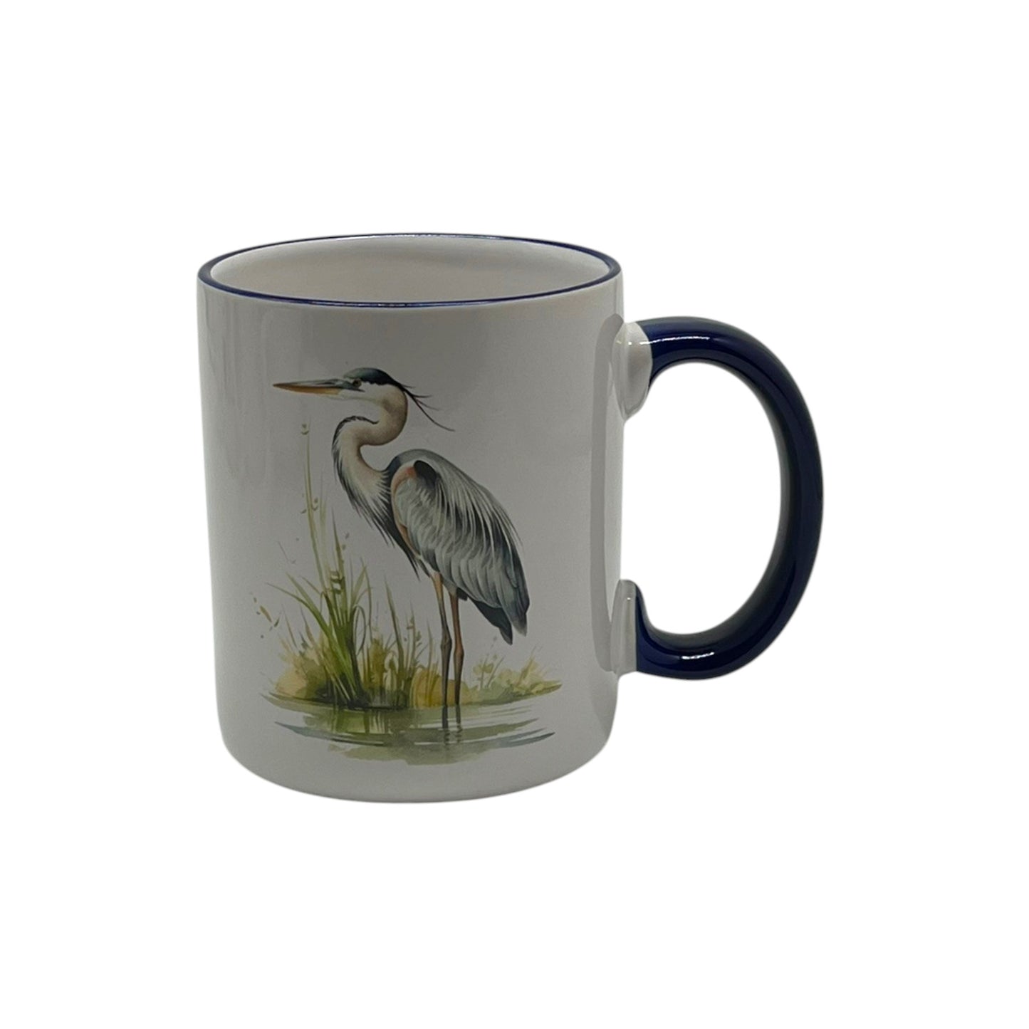 White 12-ounce stoneware mug featuring a graceful blue heron beside marsh grasses with a dark blue handle and coordinating rim.