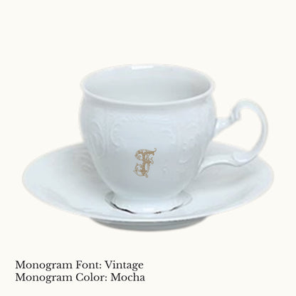 White Bernadotte porcelain cup and saucer with embossed detailing and an ornate custom letter F monogram in Mocha.