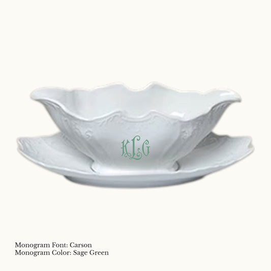 White 14-ounce Bernadotte porcelain gravy boat with an attached tray, embossed detailing, and a Carson monogram in Sage Green.