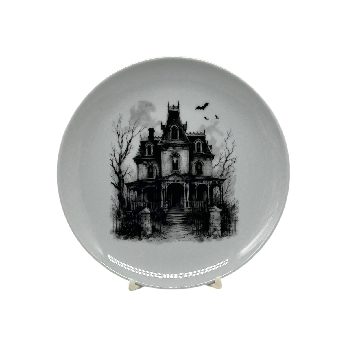 Haunted Manor 6.25 inch Halloween coupe plate with black-and-white Victorian haunted house, bare trees, wrought-iron gate and flying bats