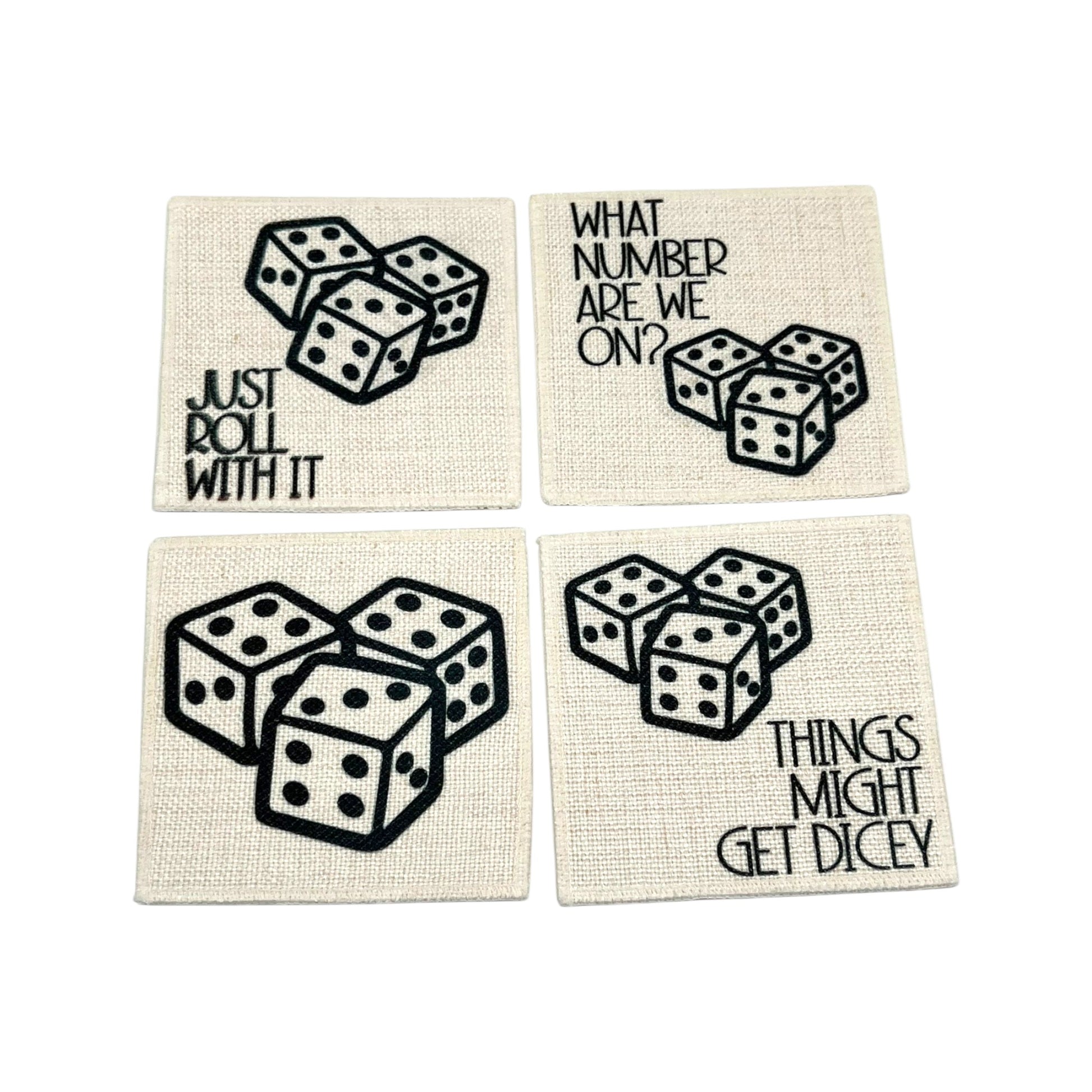 Set of four linen dice coasters with black dice artwork and funny game night sayings including Just Roll With It and Things Might Get Dicey