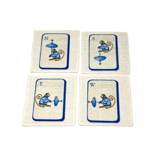 The Four Winds Mahjong linen coaster set of four featuring North South East and West chinoiserie monkeys in blue on natural linen