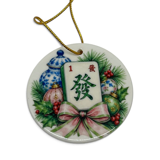 Yuletide Mahjong 3 inch porcelain Christmas ornament with mahjong tile, blue and white chinoiserie jars, greenery, berries, ornaments and pink bow