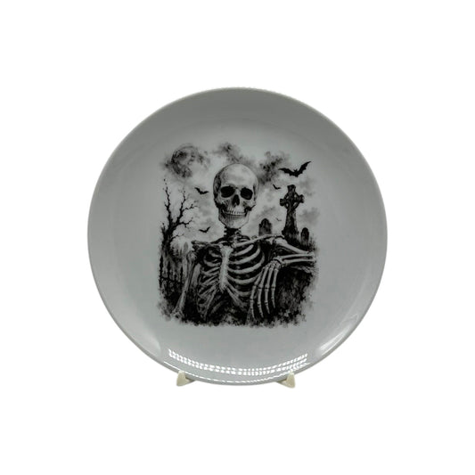 Black and white haunted graveyard skeleton 6 1/4 inch coupe plate with bats and gothic cemetery scene