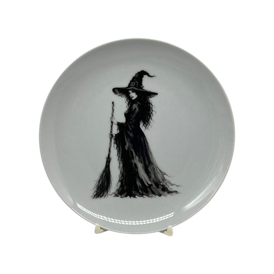 Midnight Witch 6.25 inch Halloween coupe plate featuring black-and-white witch artwork with pointed hat, flowing gown and broom